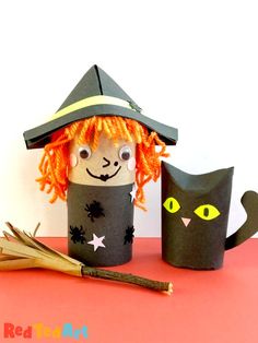 an orange haired cat sitting next to a paper cup with a witches hat on it