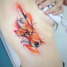 a close up of a woman's thigh with a tattoo on it that has an image of a fox