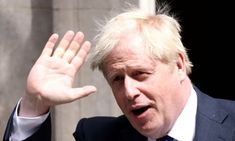 a man in a suit and tie holding his hand up