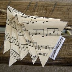 several pieces of paper with musical notes on them hanging from a wooden fence post or bench