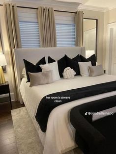 a bed with black and white pillows in a bedroom