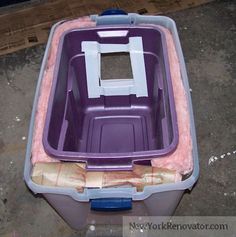 a purple and white plastic container sitting on top of a cement floor next to cardboard boxes