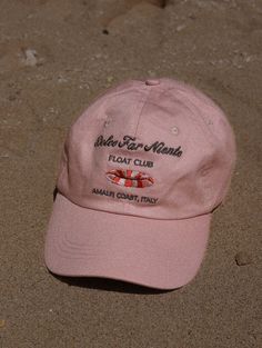 Inspired by the Dolce Far Niente lifestyle. Floating under the stunning Positano coastline, soaking up the art of doing nothing. Light pink cap, embroidery in taupe & orange, with a luxe satin interior lining. Embroidered Logo Beach Visor Hat, Beach Visor Hat With Embroidered Logo, Casual Beach Baseball Cap With Embroidered Logo, Beach Baseball Cap With Embroidered Logo, Beach Dad Hat With Embroidered Logo, Pink Baseball Cap For Beach With Curved Bill, Pink Dad Hat With Curved Visor For Summer, Pink Curved Visor Dad Hat For Summer, Pink Dad Hat With Embroidered Logo