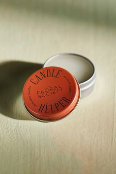 an orange lip bale sitting on top of a table next to a white container