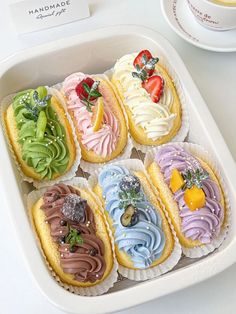 a tray filled with assorted pastries sitting on top of a table next to a cup of coffee