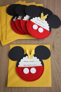 mickey mouse birthday party favors with name tags and ears on the front, in yellow envelopes