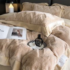 a bed covered in blankets and pillows with pictures on the pillow case next to it