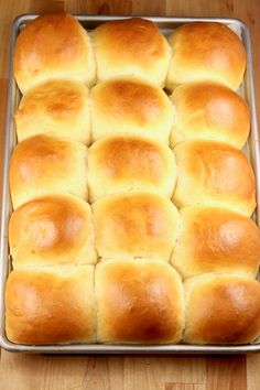 a pan filled with bread rolls on top of a wooden table