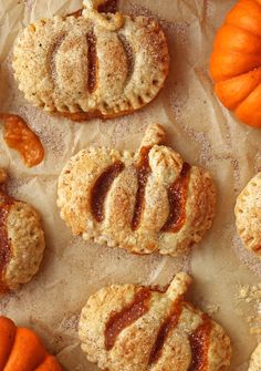 several different types of pastries on wax paper next to pumpkins and gourds