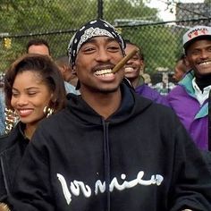 a group of people standing next to each other in front of a chain link fence