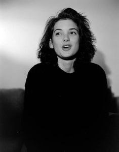 a black and white photo of a woman sitting on a couch with her mouth open