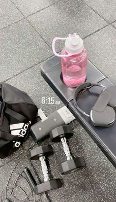 the contents of a gym bag are laid out on the ground next to a water bottle