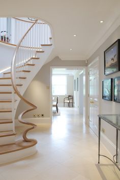 there is a spiral staircase in the middle of this room with white tile flooring