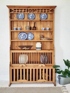 a wooden china cabinet with plates and cups on it