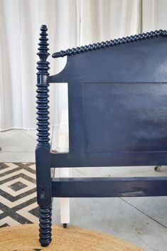 an upholstered bed frame with blue paint and black metal posts on the headboard