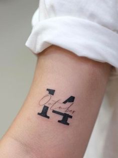 a woman's arm with a tattoo that has the number four on it and an arrow