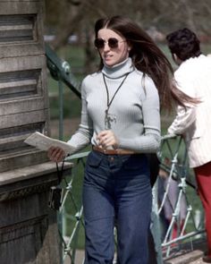 a woman with long hair walking down the street