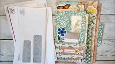 an assortment of scrapbook pages and papers on a table with some paper in front of them