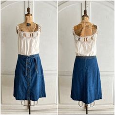 "Landlubber vintage denim skirt with logo buttons and oversized pockets. The elastic at the back of the waist has lost its stretch. So, please, check measurements for fit. The fabric belt helps keep it in place.  Measurements taken with skirt laid flat. waist 15\" hips 20\" length 24.5\"" Vintage Medium Wash Skirt For Summer, Vintage Denim Skirt With Button Closure, Vintage Dark Wash Denim Skirt For Summer, Vintage Cotton Denim Skirt, Vintage Medium Wash Cotton Denim Skirt, Vintage Denim Skirt With Pockets, Retro Medium Wash Cotton Skirt, Vintage Denim Blue Denim Skirt, Vintage Denim Blue Skirt