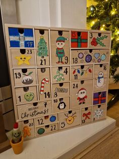 a wooden calendar sitting on top of a table next to a christmas tree