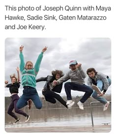 four people jumping in the air with their hands up and one person holding his arms out