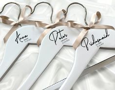 three pairs of personalized wedding hangers with ribbons