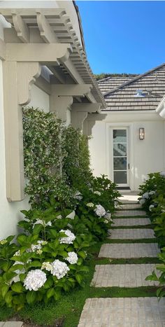 this is an image of a house with white flowers in the front and side yard