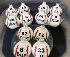 six baseball ornaments with numbers on them are sitting in a glass bowl, ready to be used as christmas ornament