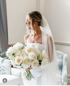 a woman in a wedding dress holding a bouquet of flowers