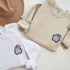 🎄🐧Celebrate this festive season with an extra touch of warmth and cuteness with our Embroidered Matching Couples Christmas Sweatshirt! Imagine strolling through a winter wonderland wearing adorable matching sweatshirts, showcasing delightful penguins donned in Santa hats. You can personalize your Christmas Sweatshirt with a choice of a pink or blue hat, creating a sweet and unique touch for you and your significant other. It's not just a Christmas Sweater; it's a token of love and togetherness during the most wonderful time of the year. Our Embroidered Sweatshirt is crafted with impeccable Custom Embroidery, ensuring every stitch tells a story of festive cheer and love. The comfort and style of our Embroidered Crewneck are unmatched, promising you not just a garment, but a cozy embrace t Couple Disney Sweaters, Couples Sweatshirts Embroidery, Matching Christmas Jumpers Couples, Embroidery Couple Design Sweater, Custom Embroidered Sweatshirt Couple, Christmas Sweatshirt Ideas, Penguin Embroidery, Xmas Couple, Sweatshirt Ideas