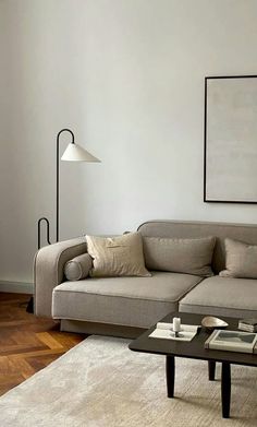 a living room with a couch, coffee table and lamp