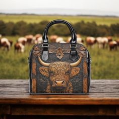 Bring a touch of rugged charm to your style with this cool handbag featuring a striking image of a Highland cow (or maybe it's a bull--either way, it's totally majestic)! The design looks like it's carved into classic tooled leather, but it's actually just a printed illusion on smooth faux leather. No rough texture here, just a flawlessly detailed look that captures the spirit of the countryside. With the bold Highland cow image on both sides, this bag is perfect for those who love a bit of rust Western Cowgirls, Cow Girl, Soft Bristle Brush, Cow Boy, Cowboy And Cowgirl, Highland Cow, Leather Material, Leather Tooling, Shoulder Handbags