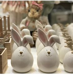 white ceramic rabbits lined up in front of wooden boxes and teddy bear figurines