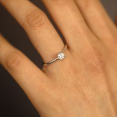 a woman's hand with a diamond ring on it