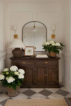 a dresser with flowers and a mirror on it