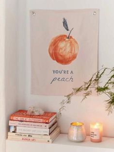 a white shelf topped with books and candles