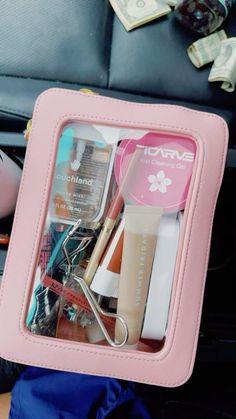 the contents of a travel bag are neatly organized in a pink case, including makeup and eyeliners