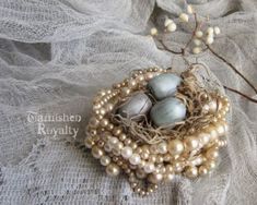 three eggs are in a nest with pearls