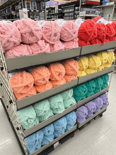 several skeins of yarn are on display in a grocery store with other items