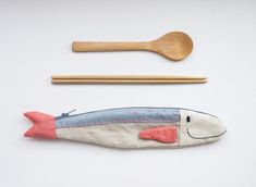 a wooden spoon and fork next to a stuffed fish