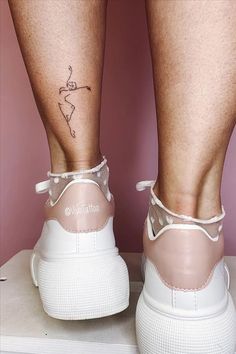 a woman's legs with tattoos on them and her shoes in the shape of tennis shoes