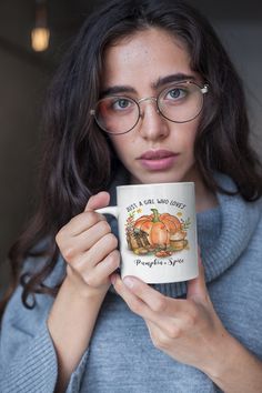 a woman wearing glasses holding a coffee mug