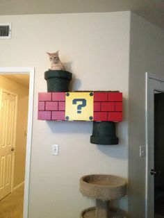 a cat sitting on top of a red and yellow brick wall with a question mark