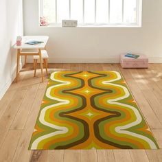 an area rug in the corner of a room with wooden flooring and white walls