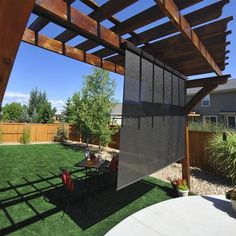 a backyard with grass and wooden pergols