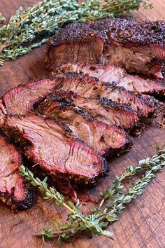 sliced up steak with herbs on a cutting board