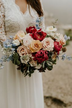 a woman holding a bouquet of flowers in her hands