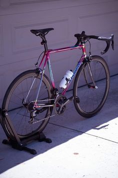 a bike parked in front of a garage door with a water bottle strapped to it