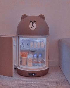 a brown bear shaped refrigerator with drinks in it's door and ice cream on the inside