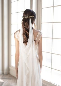 the back of a bride's dress with a veil on her head